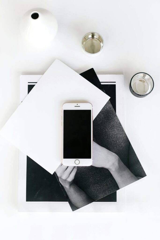 pexels-photo-6203311-6203311 A flat lay photo of a minimalist workspace featuring a smartphone, books, and a vase.